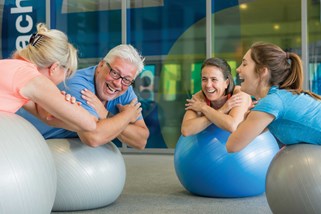 En gruppe af mennesker træner med gymnastikbolde