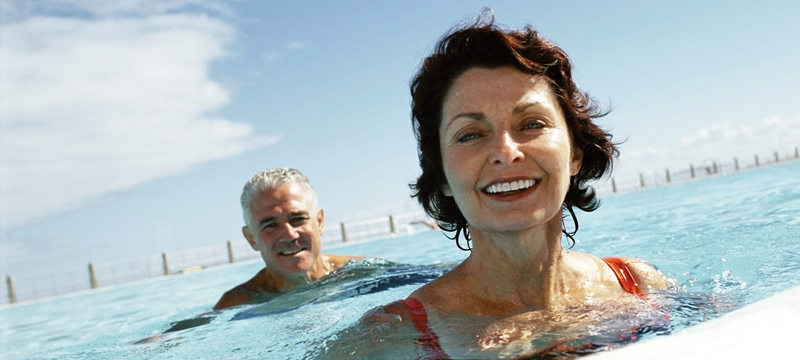 Et par svømmer i en pool