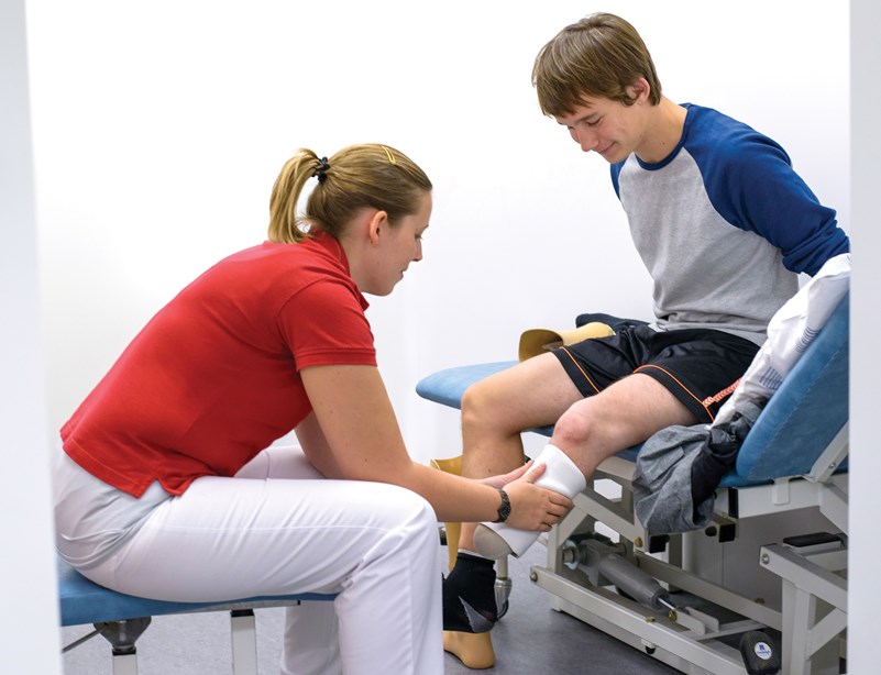 Ung mand får hjælp til at sætte sin proteseliner på