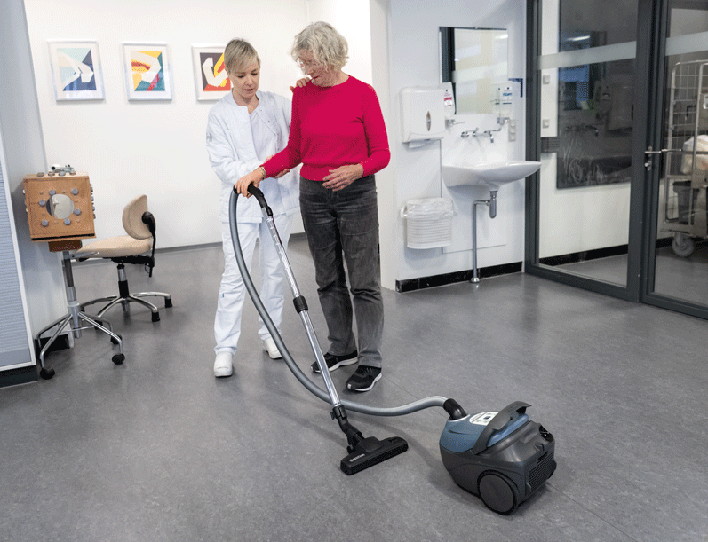 Kvinde støvsuger med sin armprotese - Sahva