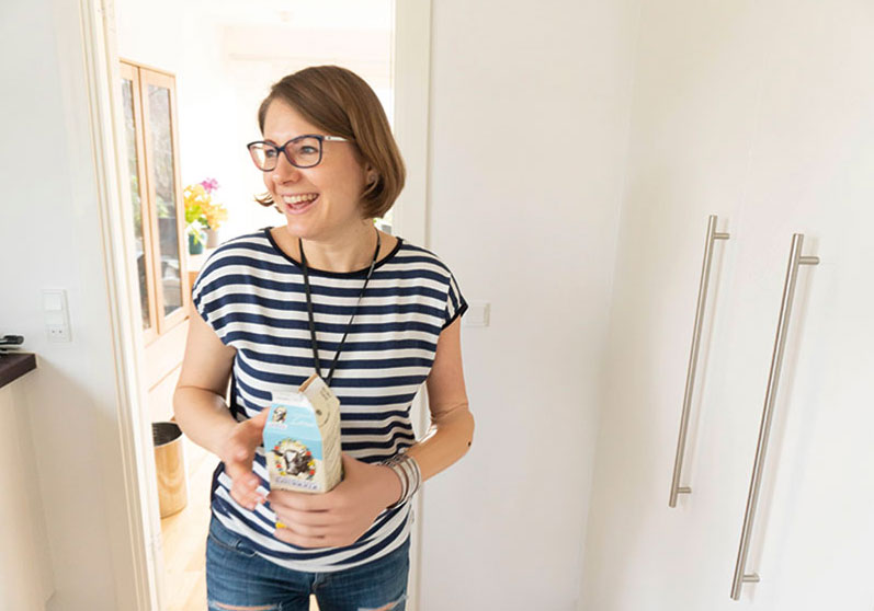 Kvinde med bionisk hånd holder en mælkekarton - Sahva