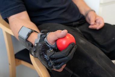 Mand laver hånd øvelser med rød bold